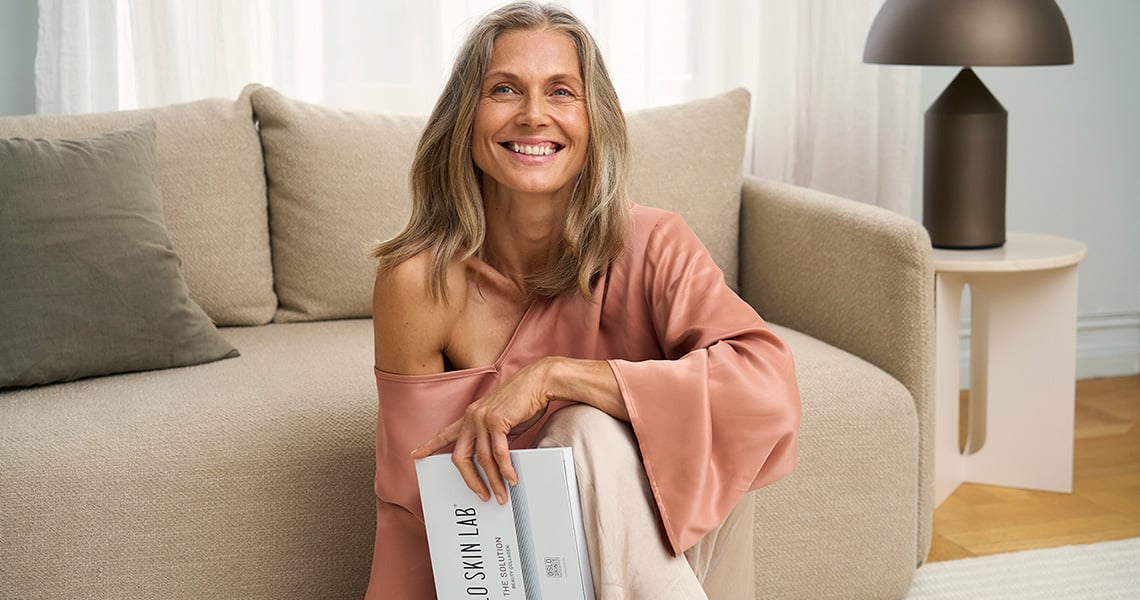 Frau vor Sofa sitzend und The Solution haltend